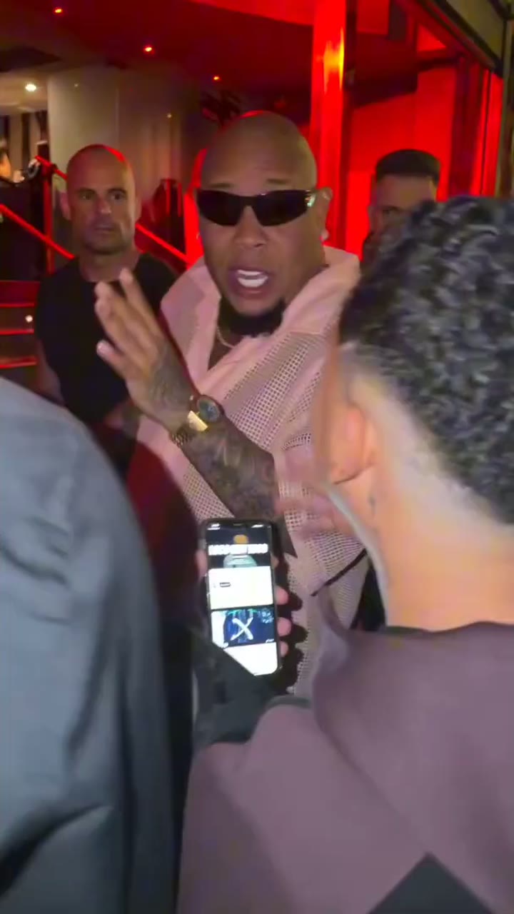The original Bulin 47 freestyle scene: the rapper in front of a red-lit venue entrance at night, Kevin Wai holding a speaker and phone